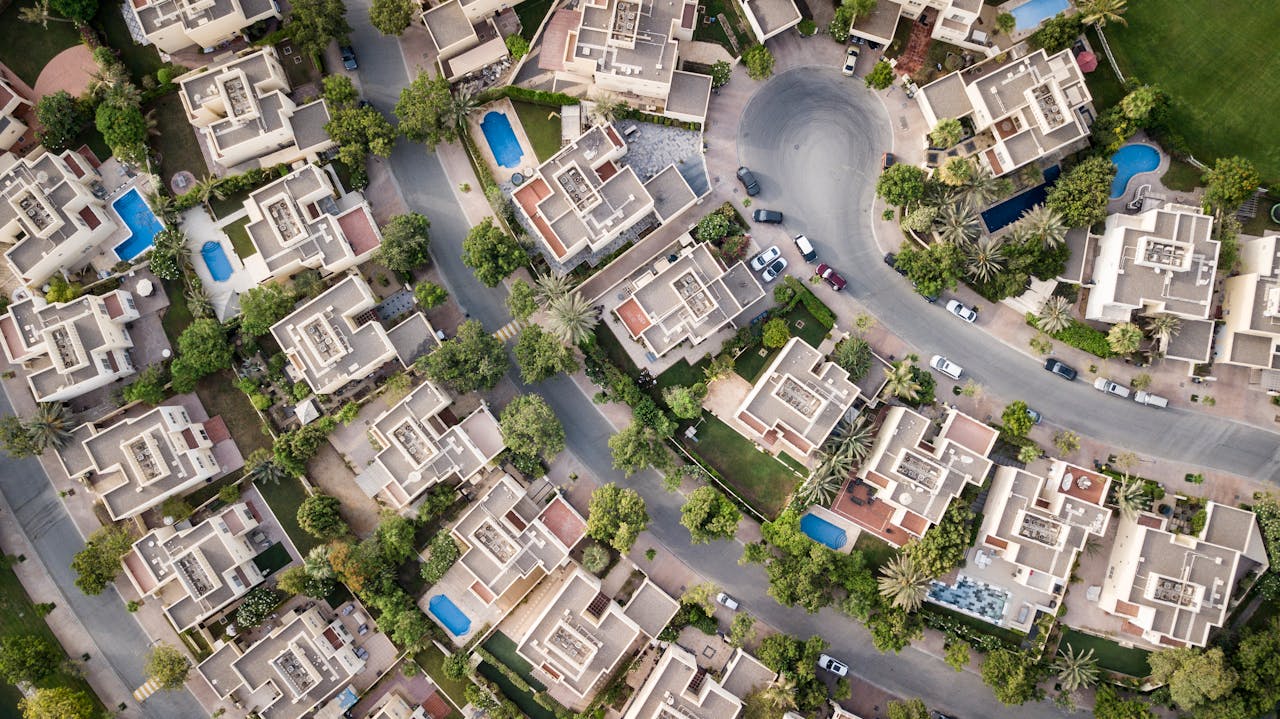 Offerings Explore a stunning aerial view of a residential area in Dubai with lush greenery and swimming pools.