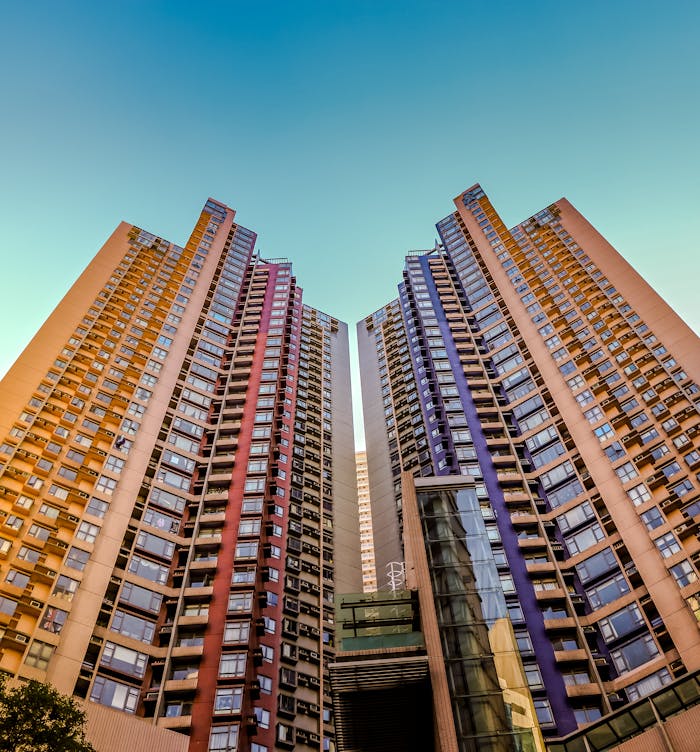 Home Tall, colorful skyscrapers reaching into the blue sky in Hong Kong, showcasing modern architecture.