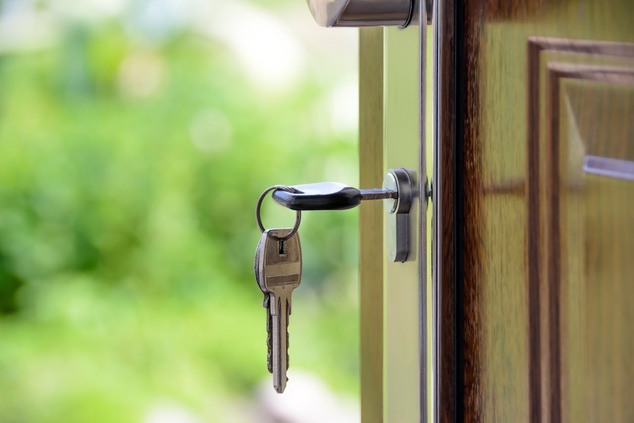 Offerings Key inserted in door lock against a blurred green background, symbolizing security and real estate.